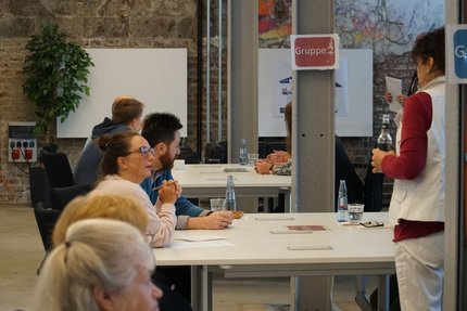 Bürger im Gespräch, sitzend an Tischen